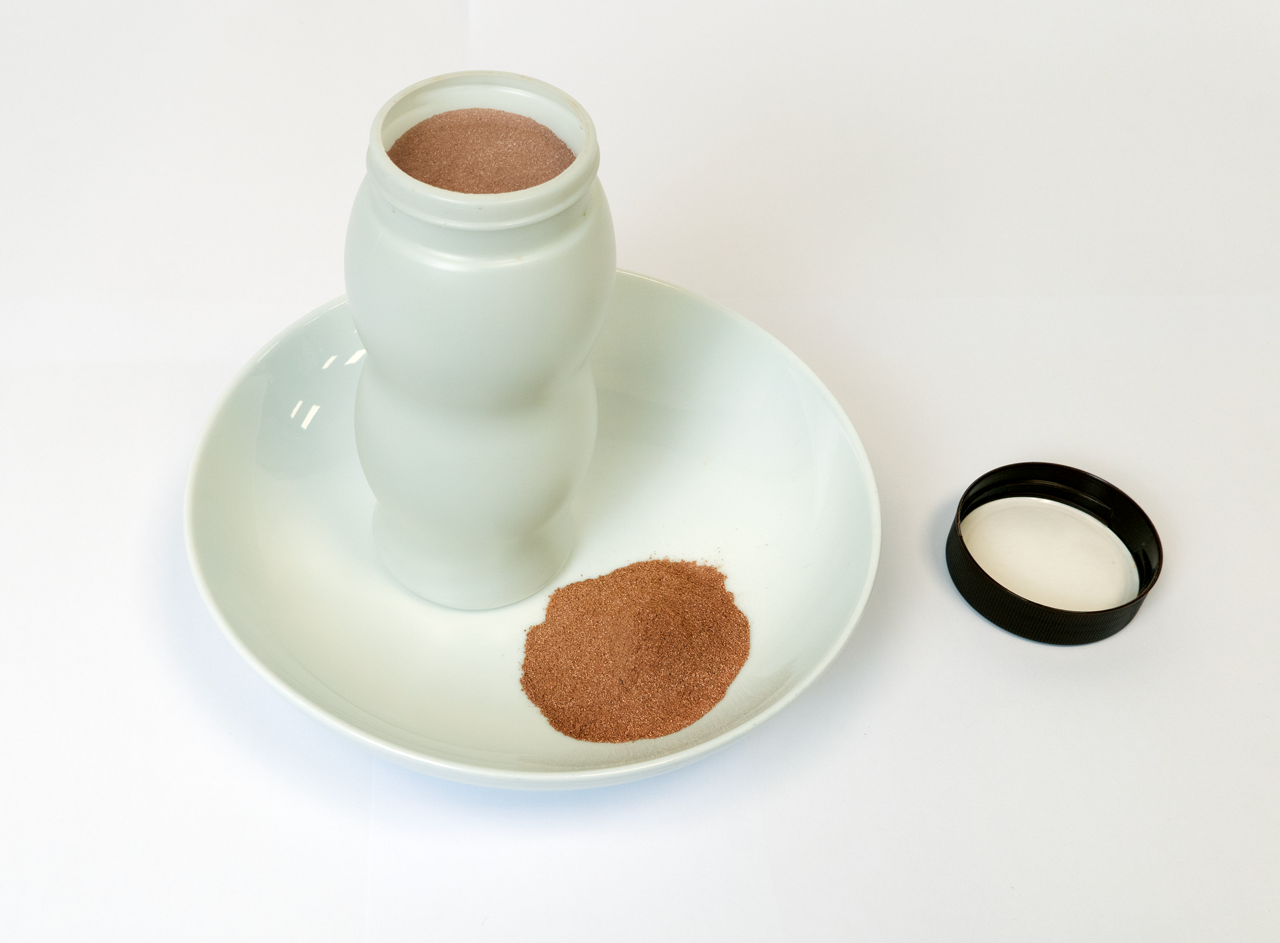 Cocoa powder product in typical original packaging where serving and pouring are customer considerations 